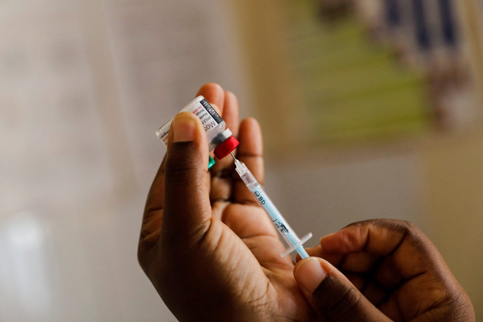 Ghanaian healthcare worker administering a vaccine.