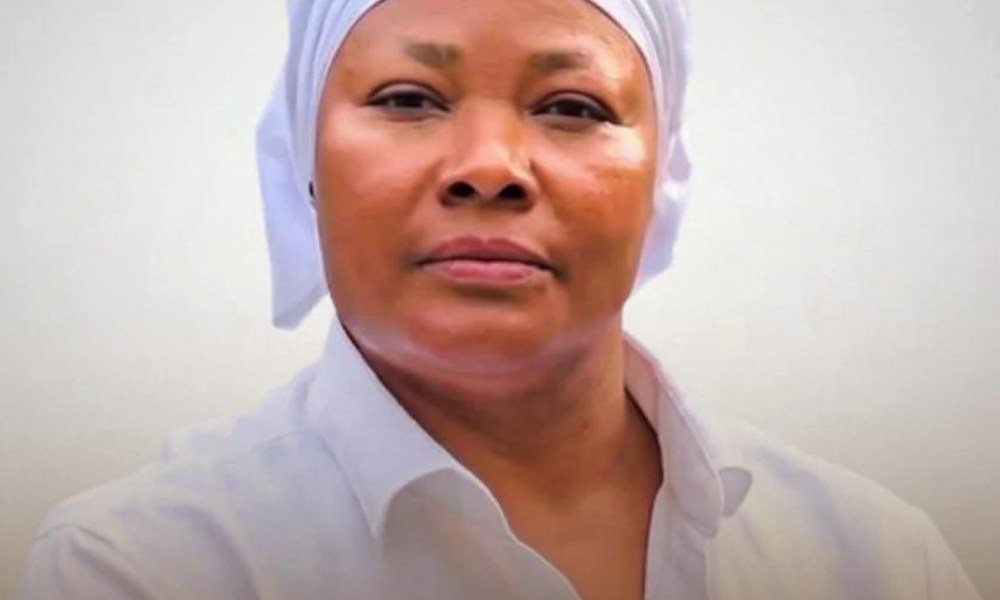 Nana Agradaa speaking passionately at a public event, surrounded by followers.