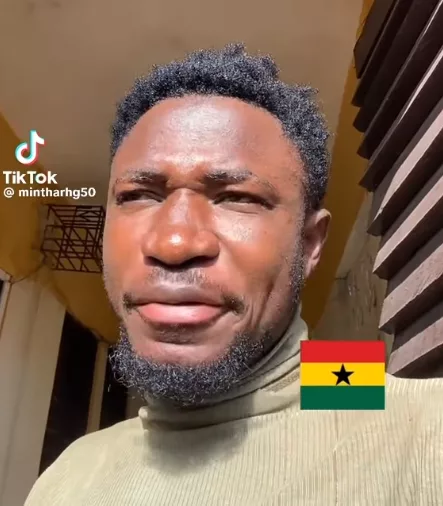 A musician speaking into a microphone while looking at a smartphone camera