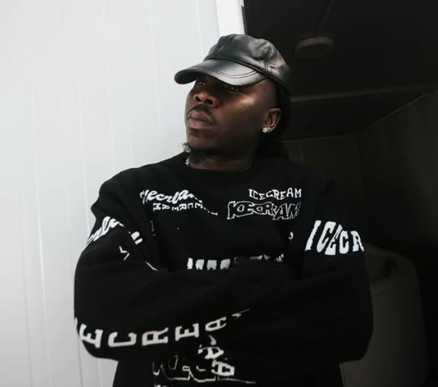 Stonebwoy performing on stage with bright lights and a cheering crowd