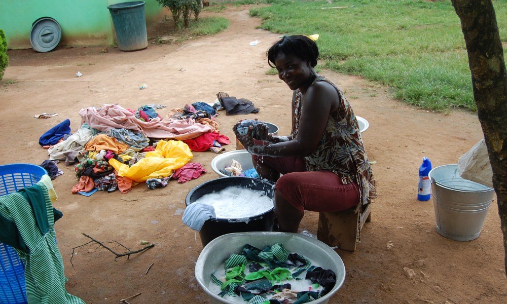 A couple happily folding laundry together on a cozy couch